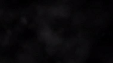 Siyah arka planda soldan sağa doğru beyaz duman bulutu soyut döngüsü akışı. Smoke veya Haze arka planı yavaş çekimde. Beyaz duman, siyah arkaplana karşı uzayda yavaşça süzülüyor. Atmosferik duman 4K Sis etkisi elementi. 