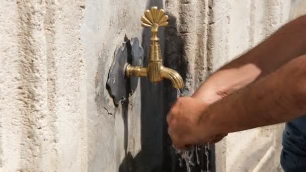 Lavado de manos, un hombre lavado de manos en la fuente histórica — Vídeos de Stock