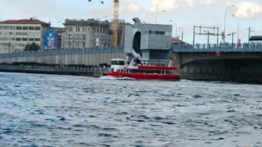 Tekne geçiyor, kırmızı tekne köprünün altından geçiyor, İstanbul 'da Galata Köprüsü.