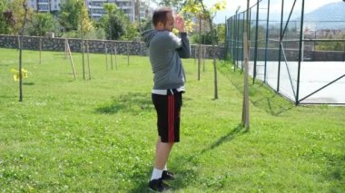 Sporcu ısınıyor, genç sporcu parkta ısınıyor.