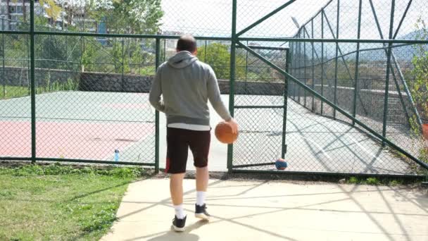 Basketbalveld, basketbalspeler die het basketbalveld betreedt — Stockvideo