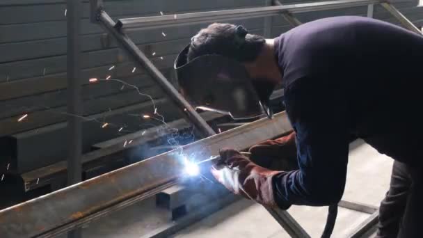 Soldador joven, soldadura de soldadura enmascarada tubos de perfil de acero, en el taller — Vídeos de Stock