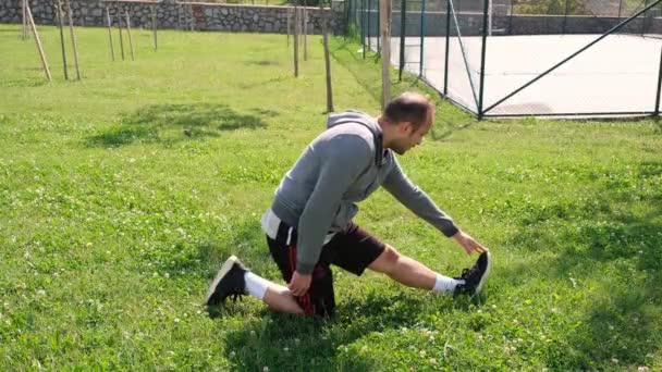 Подколенное сухожилие растяжение, молодой человек делает упражнение подколенного сухожилия растяжения — стоковое видео