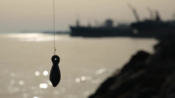 Chumbo de pesca, Pescadores chumbo é visto em silhueta pelo mar — Vídeo de Stock