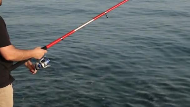 Fiskespö, man fiskar med fiskespö, nära havet — Stockvideo