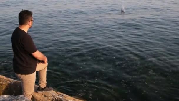 Odbijający się kamień, człowiek wrzucający kamienie do morza, odbijający — Wideo stockowe