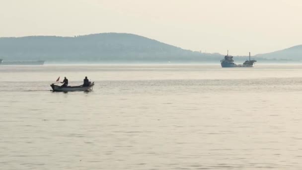Båtsmän, två båtsmän som fiskar i havet, solnedgång, bullereffekt — Stockvideo