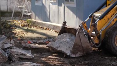 Mini dozer, mini dozer inşaat alanındaki beton blokları kaldırıyor.