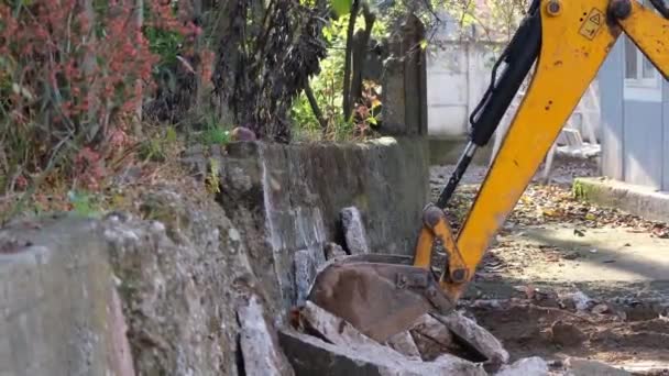 Grävmaskin, grävmaskin som bryter betongblock, zooma ut — Stockvideo