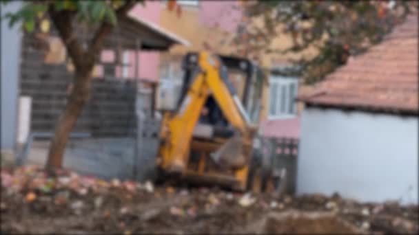 Mini excavadora, mini excavadora que llega al sitio de construcción, efecto desenfoque — Vídeos de Stock