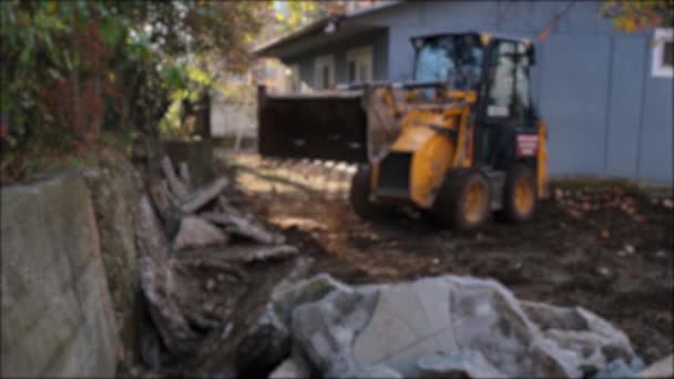 Mini excavator, mini excavator removing piles of rubble blur effect — Stock Video