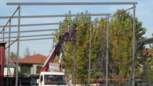 Сталеве будівництво, робітник виконує сталеві будівельні роботи з бум-ліфтом — стокове відео