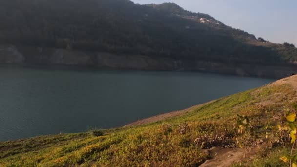 Озерна сковорідка, постріл в озеро і гору, видно через зелені луки — стокове відео