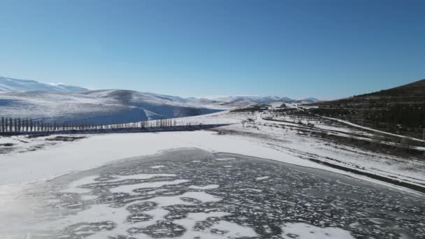 Antenn drönare vinter, drönare antenn utsikt över en frusen sjö och snöiga berg — Stockvideo