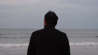 alone man, alone man in overcoat watching the sea with his back turned