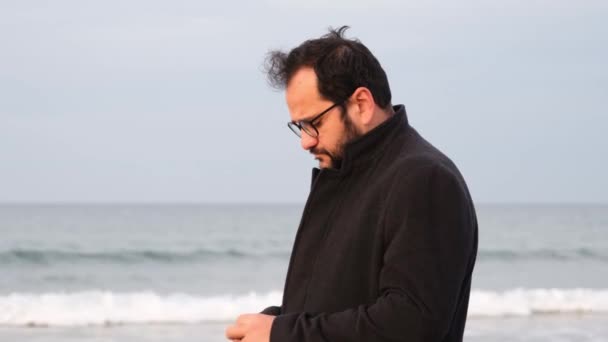 Smoking by sea, depressed man smoking by the wavy sea in autumn — Αρχείο Βίντεο