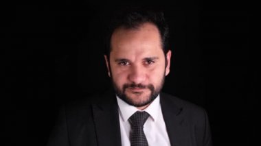 Gülümseyen adam, genç takım elbiseli adam siyah arka planda gülümseyen yavaş çekim