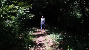 Işık huzmesi ormanında yürüyen adam