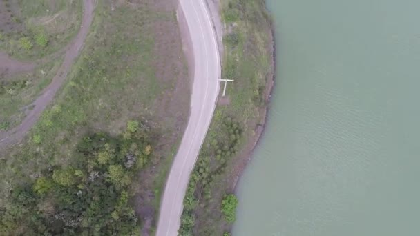 Aerial lakeside mountain road — стоковое видео