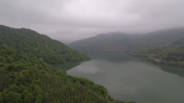 Sisli göl, hava sisli göl ve göldeki bulutların yansıması, yeşil orman.