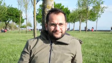 Gülümseyen adam, gülümseyen adam yeşil çayıra yaslanan adam.