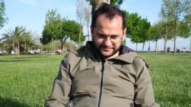 Bilgisayarla çalışan, parkta dizüstü bilgisayarıyla çalışan bir adam.