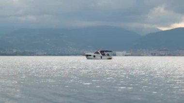 Durgun denizin ortasında beyaz bir tekne.