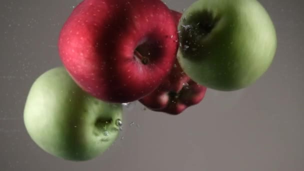 红的和绿的苹果 红的和绿的苹果扔进水里 — 图库视频影像