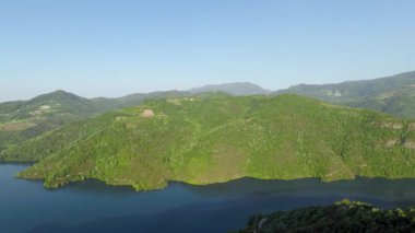 Yeşil dağ, gökyüzü mavisi göl ve yeşil dağ