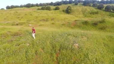 Tarlada yalnız bir adam, havadan vurulmuş yalnız bir adam, başka tarafa bakıyor.