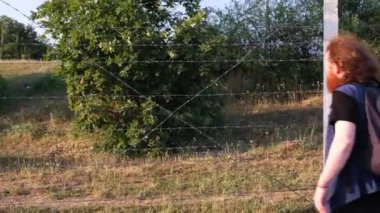 Sınırdaki mülteci, sınırdaki dikenli tellere dokunan mülteci.