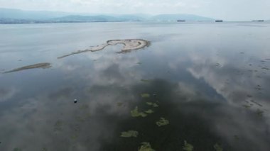 Deniz ve kuşlar, denizin üzerindeki küçük adacıklar bulutların yansıttığı