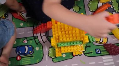  child playing toys, two caucasian child playing toys on traffic pattern carpet