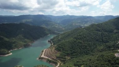 lake and mountains, aerial blue lake and green mountains pan, cloudly