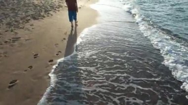 walking on beach, man walking on beach, sunset