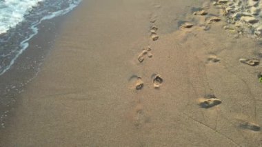 Dalgalar, havadaki ayak izleri ve sahildeki dalgalar.