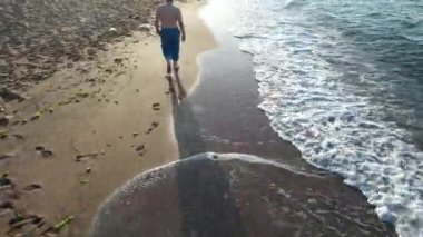  Sahilde yürüyorum, beyaz adam gün batımında sahilde yürüyorum.