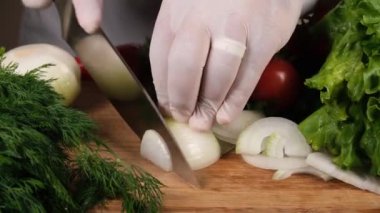 Kesme tahtasındaki keskin bıçakla soğan doğrama. Kesme tahtası, soğan, salata, domates, soğan, maydanoz, dereotu, organik gıda.
