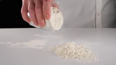 Hamur için hazırlık, şef beyaz masada hamur yapmak için un hazırlıyor.