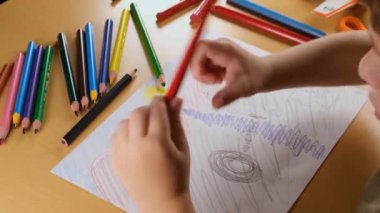 Çocuk çizimi, kağıt üzerinde illüstrasyon, renkli kalemle kağıda çizim yapan çocuk.