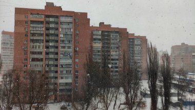 Kar yağışı, yerleşim yerlerine bakan binalar, kışın şehir manzarası, şehirde kar fırtınası, eski Sovyet tarzı evler, şehrin karla kaplı bölgesi.