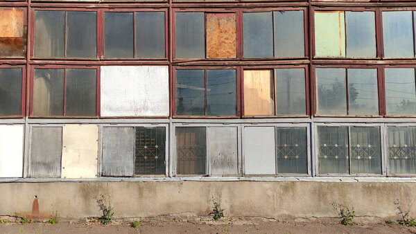 View of an old industrial building, an old factory. Wooden windows in an old factory, abandoned building