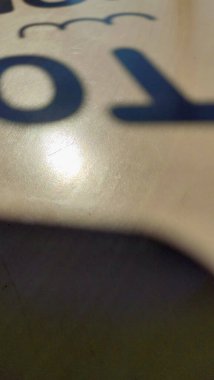 Yazılı bir masada gölge, beyaz ahşaptan yapılmış bir kafede masa, güneşli bir günde parlak bir gölge. 