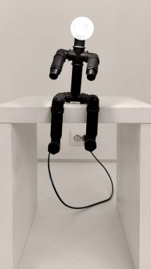 Bir insan suretinde bir lamba, parlayan bir lamba, oturan bir insan şeklinde orijinal bir lamba.