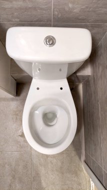 Tadilattan sonra banyonun fotoğrafı, dairede yenilenme, banyo beyaz ve gri tonlarda döşeme, klozet.