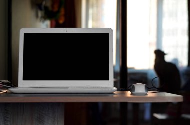 Evdeki masada dizüstü bilgisayar, dizüstü bilgisayarlı ev işi, arka planda kedi olan iş yeri, ahşap masa manzaralı beyaz laptop, siyah ekranlı dizüstü bilgisayar. 