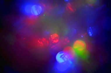 Çelenk ışıklarının bokeh etkisi ile parlak bulanık arkaplan, koyu arkaplanda bulanık ışıklar, parlak renkli noktalar, metin için arkaplan