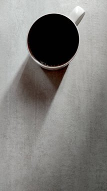 Bardak beyaz bir masanın üstünde, bardakta su, bir bardak suyun uzun gölgesi, üst manzara, bardağın yanındaki yazı için boşluk.