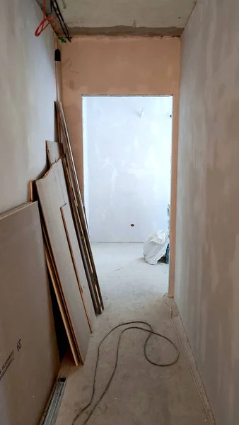 Renovation of the apartment, view of the ceiling and corridor, plastered walls, empty room, empty wall, plasterboard wall, corner of the room, doorway, electric cable