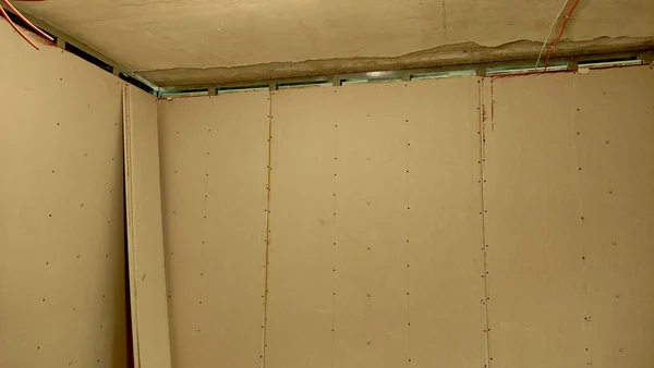 Renovation of the apartment, view of the ceiling, walls are plastered, the room is empty, the wall is empty, the wall is made of plasterboard, the corner of the room